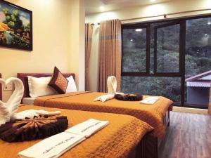 a hotel room with two beds and a window at Hoàng Phúc home - restaurant in Cat Ba