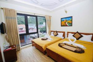 a bedroom with two beds and a large window at Hoàng Phúc home - restaurant in Cat Ba