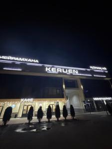 a group of birds sitting outside of a store at night at Keruen in Almaty