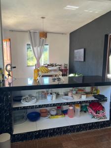a kitchen with a shelf filled with dishes at Casa do Bosque in Paty do Alferes +5 photos