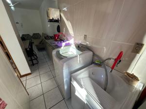a small bathroom with a tub and a sink at Apartamento em Capão da Canoa com Ar-condicionado in Capão da Canoa +13 photos