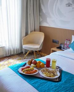 a tray of food on a bed in a hotel room at The Atlantiis Suites Nr Vishwanath Temple in Varanasi