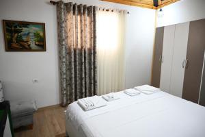 a bedroom with a white bed and a window at The Parkside Villa Apartment II in Berat +15 photos