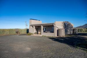 a small white building with a driveway in front of it at Donkieshoek Accommodation & Campsite, Welgemoed Street, Calvinia in Calvinia
