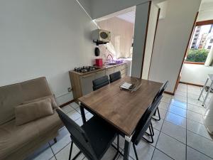 a living room with a wooden table and a couch at Apartamento em Capão da Canoa com Ar-condicionado in Capão da Canoa