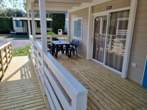 a deck with a table and chairs on a house at Camping La Rocca in Manerba del Garda