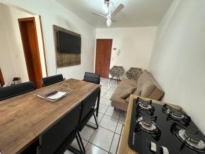 a living room with a wooden table and a kitchen at Apartamento em Capão da Canoa com Ar-condicionado in Capão da Canoa
