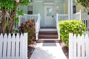 a white picket fence in front of a house at Blue House Getaway - 2BR 3BA Coastal Villa in Duck Key +37 photos