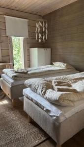 a bedroom with two beds in a room with wooden walls at Villa Narikko in Sysmä
