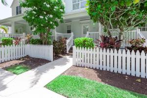 a white picket fence in front of a house at Blue House Getaway - 2BR 3BA Coastal Villa in Duck Key