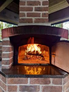 a brick oven with a fire in it at Villa Narikko in Sysmä