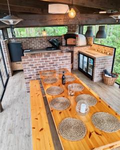 a wooden table in a kitchen with a brick oven at Villa Narikko in Sysmä