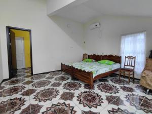 a bedroom with a bed and a chair in it at Guest House Machaxela in Gonio