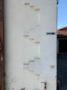 a white wall with stairs on the side of it at Tomeline in Tartas