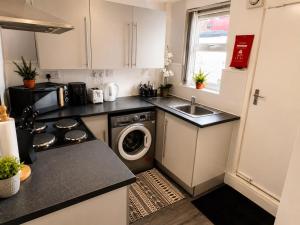 a small kitchen with a washer and dryer in it at Room 2 Shared House 10 min from Center in Liverpool