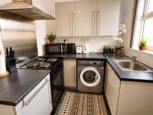 a kitchen with a washing machine and a sink at Room 2 Shared House 10 min from Center in Liverpool +8 photos