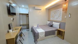 a small room with a bed and a desk at La Casa Princesa Inn in Puerto Princesa City