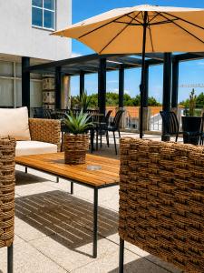 a patio with a table and an umbrella at INOTEL Paços de Ferreira in Paços de Ferreira