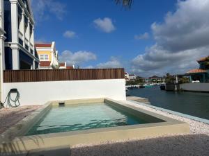 a swimming pool on the side of a building next to the water at Lagoon Lounge - Waterfront villa with private pool in Kralendijk