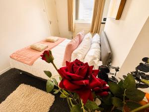 a bedroom with a bed with red roses on the floor at Room 2 Shared House 10 min from Center in Liverpool