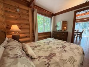 a bedroom with a bed in a room with wooden walls at Chalet Le Boisé SPA et Rivière in Brownsburg