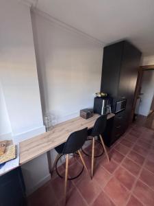 a kitchen with a wooden table and two chairs at Fernández Vega 6 in Ponteareas
