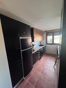 a kitchen with a black refrigerator and a tile floor at Fernández Vega 6 in Ponteareas
