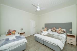 a bedroom with two beds and a ceiling fan at Donkieshoek Accommodation & Campsite, Welgemoed Street, Calvinia in Calvinia