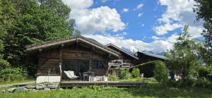 a log cabin with a porch and a chair at Cabane dans la vallée de Chamonix in Servoz