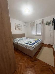 a small bedroom with a bed and a window at Apartman TOPLA in Topla