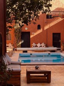 a swimming pool with a couch and a table at Guest House Bagdad Café in Aït Benhaddou +47 photos