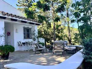 a patio with chairs and tables in front of a house at Descansadero in Bolonia