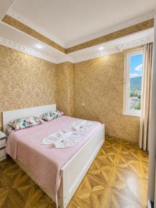 a bedroom with a bed with pink sheets and a window at Historic Centre Apartment Kutaisi in Kutaisi