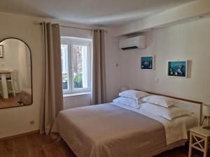 a bedroom with a bed and a large window at Studio Riva in Hvar