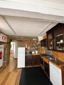 a kitchen with wooden cabinets and a white refrigerator at Casa do Avô Grande in Esposende