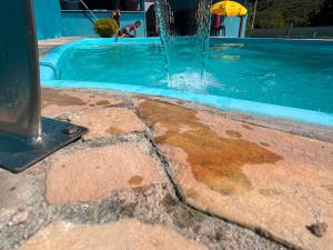 a swimming pool with a water fountain at Cantinho RMA in Bom Jesus dos Perdões +8 photos