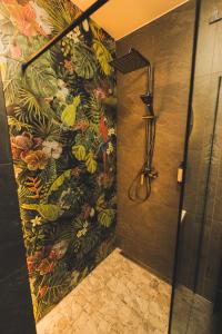 a bathroom with a shower with a floral wallpaper at Jacuzzi Siesławska Top Apartment in Busko-Zdrój