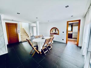 a dining room with a table and chairs and a staircase at Casa do Prado in Pontevedra