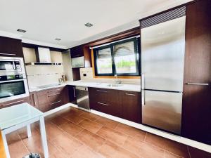 a kitchen with wooden cabinets and stainless steel appliances at Casa do Prado in Pontevedra +6 photos