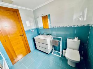 a blue bathroom with a toilet and a sink at Casa do Prado in Pontevedra