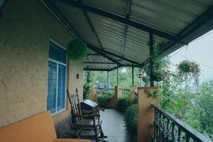 a porch with chairs and awning on a house at Mellowmine Premier in Kokliyal Gaon