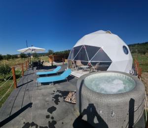 a large tent with a hot tub and chairs at GlampingDenis Igloo in Mihăeşti
