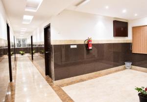 an empty lobby with a fire extinguisher on the wall at HOTEL NEAR KASHI VISHWANATH VARANASI SHREE R-KRISHNA - wifi - Lift - FAMILY HOTEL in Varanasi
