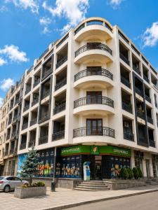 a large white building with a store in front of it at Historic Centre Apartment Kutaisi in Kutaisi