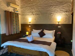 a bedroom with a large bed with white pillows at Mellowmine Premier in Kokliyal Gaon