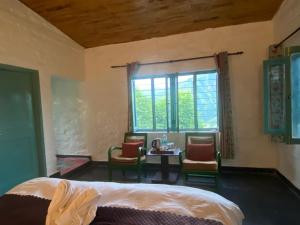 a bedroom with a bed and a table and chairs at Mellowmine Premier in Kokliyal Gaon