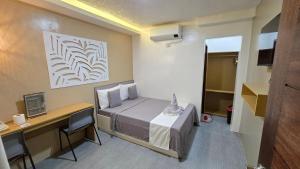 a small room with a bed and a desk at La Casa Princesa Inn in Puerto Princesa City +135 photos