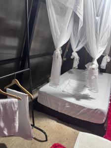 ein Bett mit weißen Vorhängen in einem Zimmer in der Unterkunft Amazon Oasis in Leticia