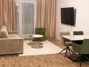 a living room with a couch and a table and chairs at Edna House in Montigny-lès-Cormeilles
