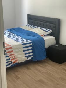 a bedroom with a bed with blue and white sheets at Edna House in Montigny-lès-Cormeilles